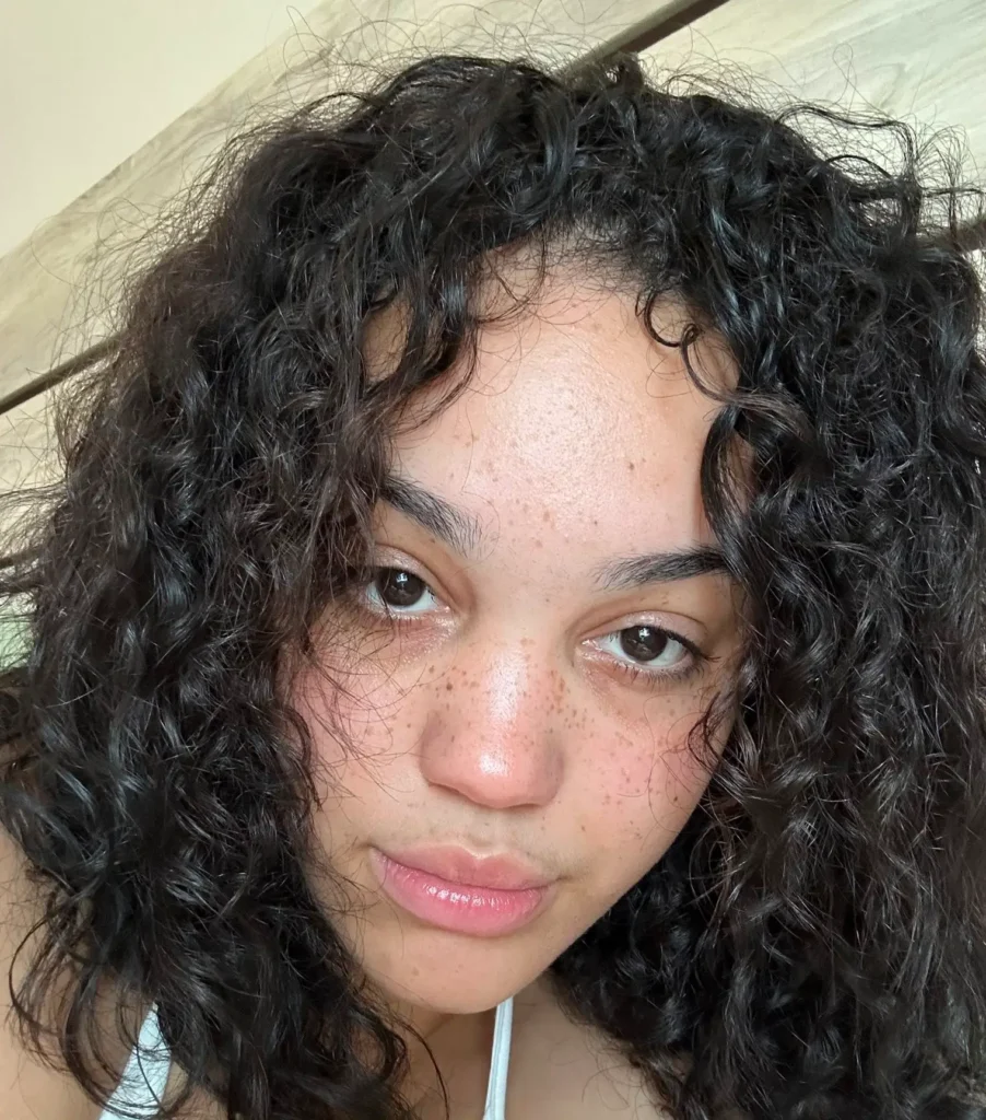 a woman with curly hair and freckles taking a selfie